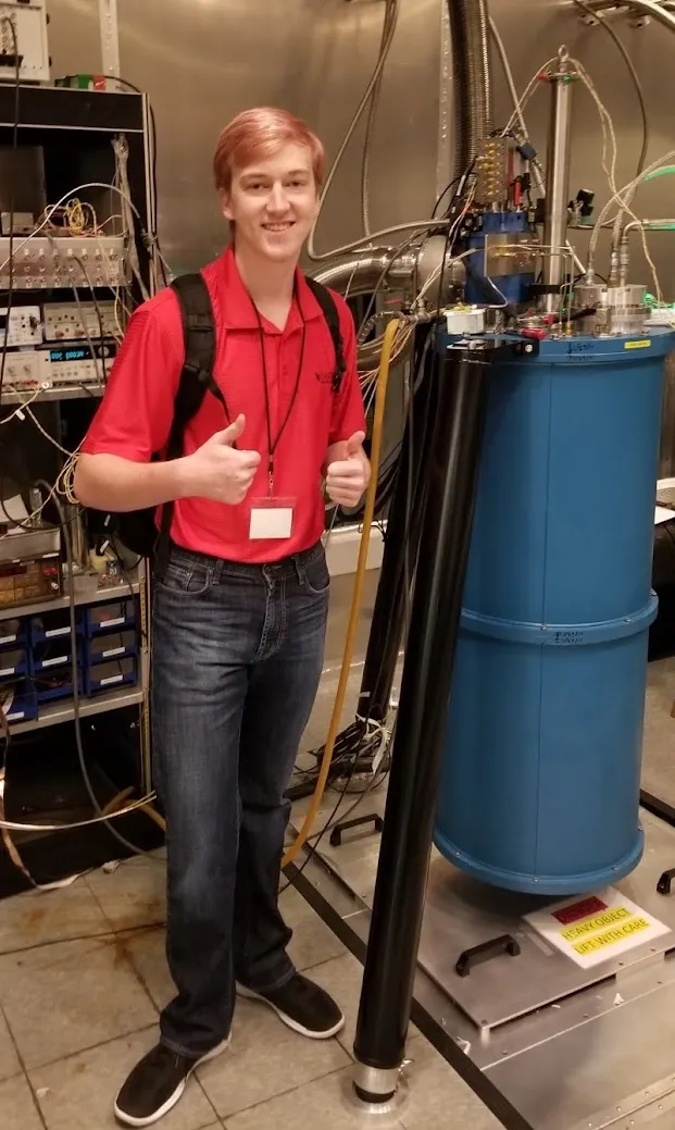 Cade beside a quantum computing display.